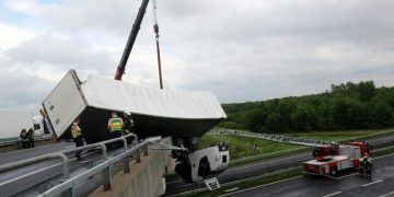 Accident spectaculos. Cabină de TIR suspendată peste autostradă, camion aruncat de vânt peste parapet