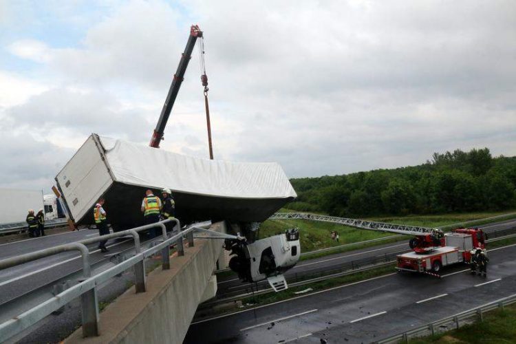Accident spectaculos. Cabină de TIR suspendată peste autostradă, camion aruncat de vânt peste parapet