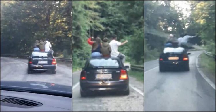 Mai mulţi tineri, dintre care unul pare a fi copil, filmaţi pe Transfăgărăşan pe capota maşinii