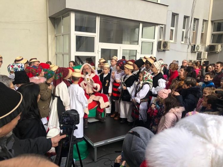 Moș Crăciun, ajutat de unul dintre renii săi, cu daruri pentru copiii angajaților Spitalului Județean