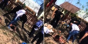 Șef de post, filmat când bătea un tânăr imobilizat – video