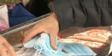 Femeie filmată cum șterge un mănunchi de măști de protecție de racla cu moaștele Sf. Parascheva