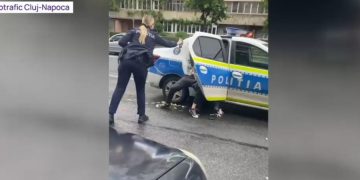 O poliţistă pulverizează spray lacrimogen în ochi colegului ei, care încerca să imobilizeze un individ recalcitrant