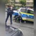 O poliţistă pulverizează spray lacrimogen în ochi colegului ei, care încerca să imobilizeze un individ recalcitrant