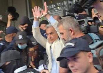 Călin Georgescu ridică mâinile încătușate la ieșirea de la DIICOT pentru a fi dus în arest