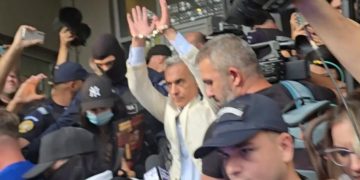 Călin Georgescu ridică mâinile încătușate la ieșirea de la DIICOT pentru a fi dus în arest